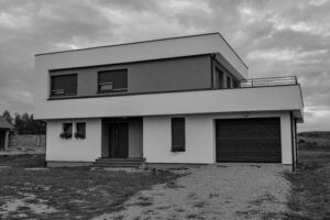Grayscale photo of a modern two-story house with a garage, showcasing contemporary architecture.